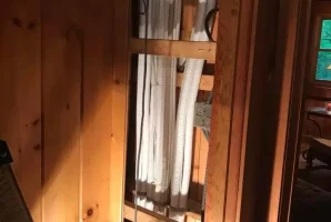 Electrical conduits neatly arranged inside a wooden wall panel for home wiring solutions.