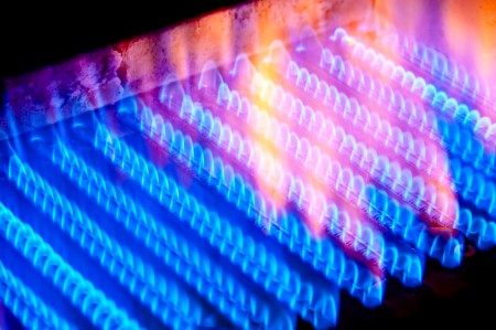 Blue flames on a gas stove burner provide efficient heat for cooking.