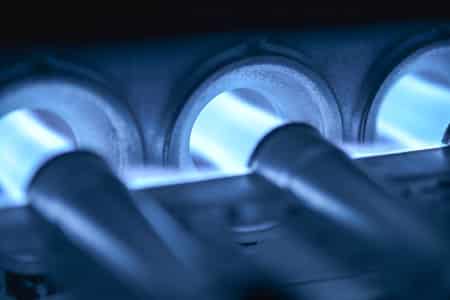 Close-up of blue flames in a furnace burner for heating systems.