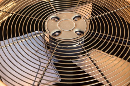 Close-up of an industrial metal fan with protective grille and blades.