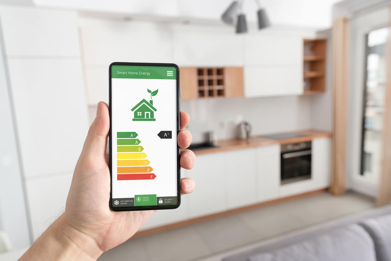 Homeowner using an energy efficiency app on their phone,, tracking AC efficiency and summer energy bills.