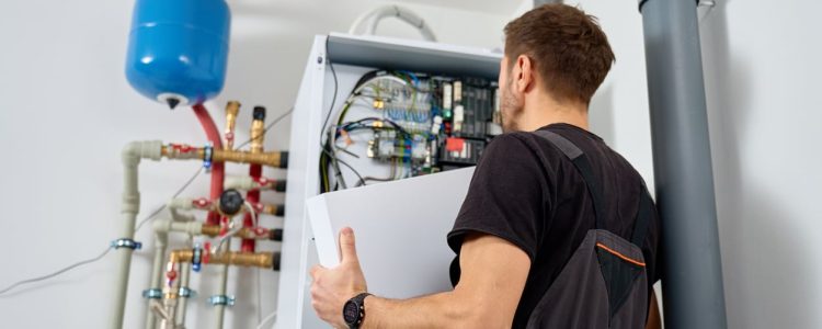 Technician installing a geothermal heat pump system in a New York home’s basement.