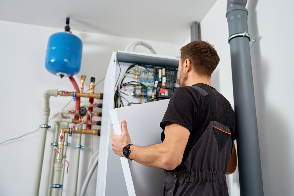 Technician installing a geothermal heat pump system in a New York home’s basement.